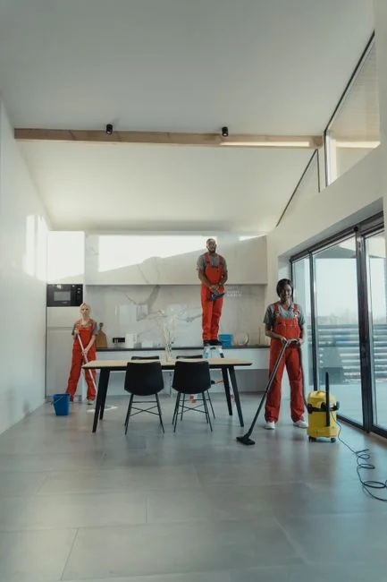 A worker cleaning skyscraper windows with a harness in an urban setting.